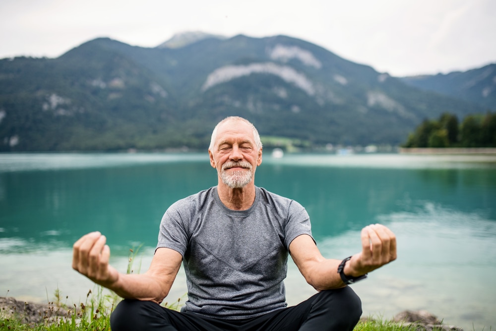 homme âgé pratiquant le yoga en extérieur