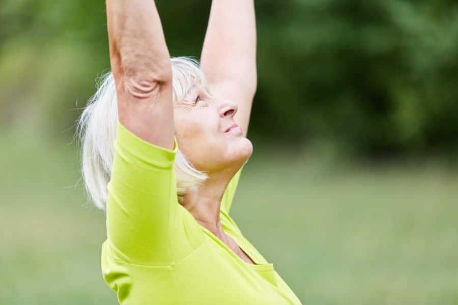 bien vieillir grâce au yoga - femme pratiquant le yoga en pleine nature