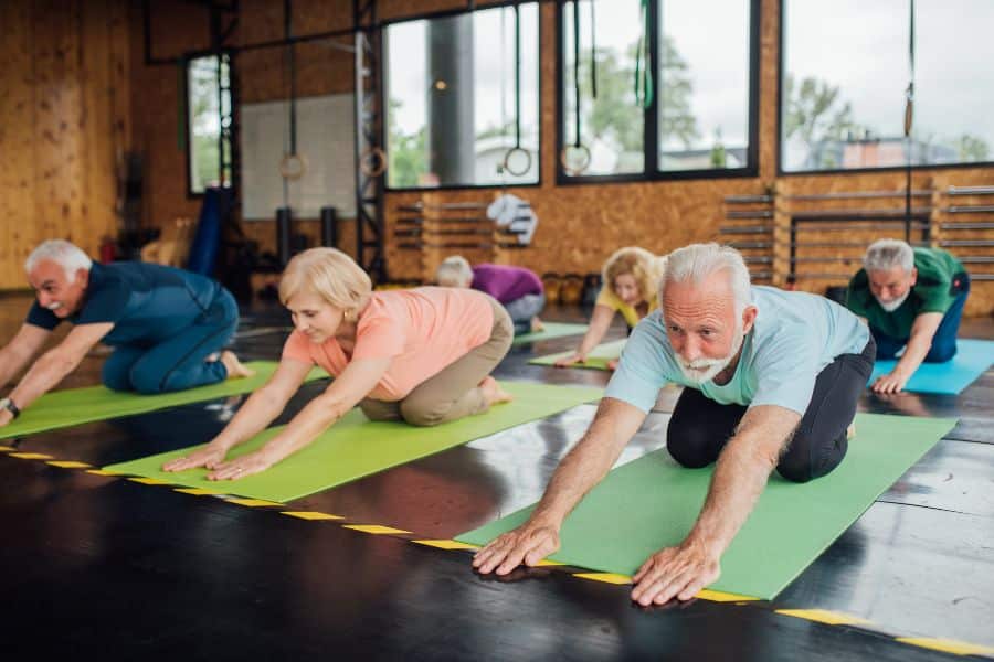 groupe de seniors en train de faire du yoga pour bien vieillir