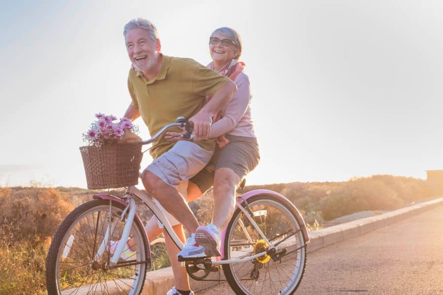 s'amuser à la retraite - deux retraités souriant sur un vélo