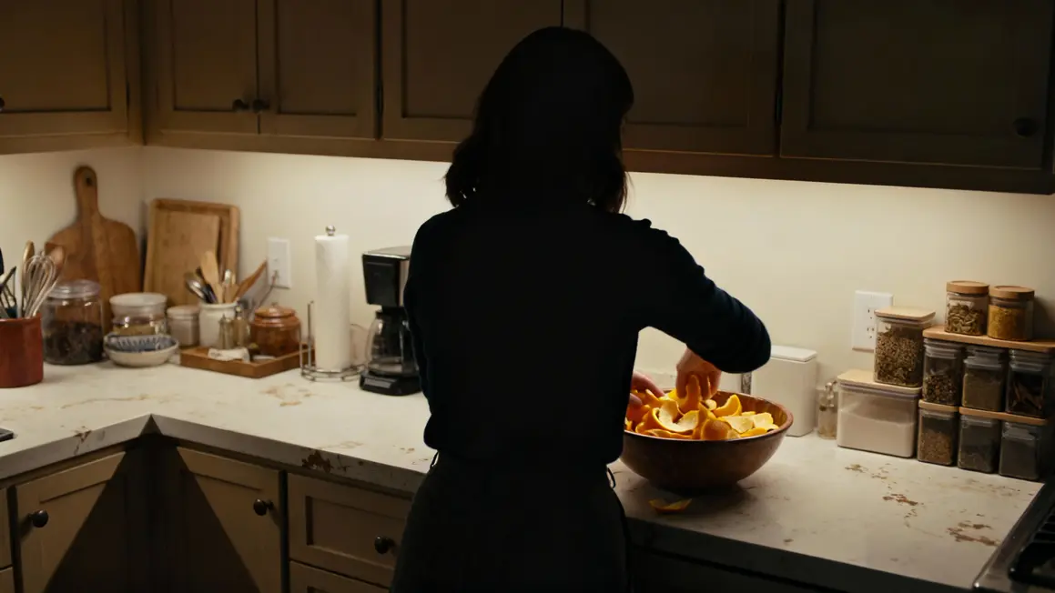 femme fouillant compotier peaux orange cuisine maison